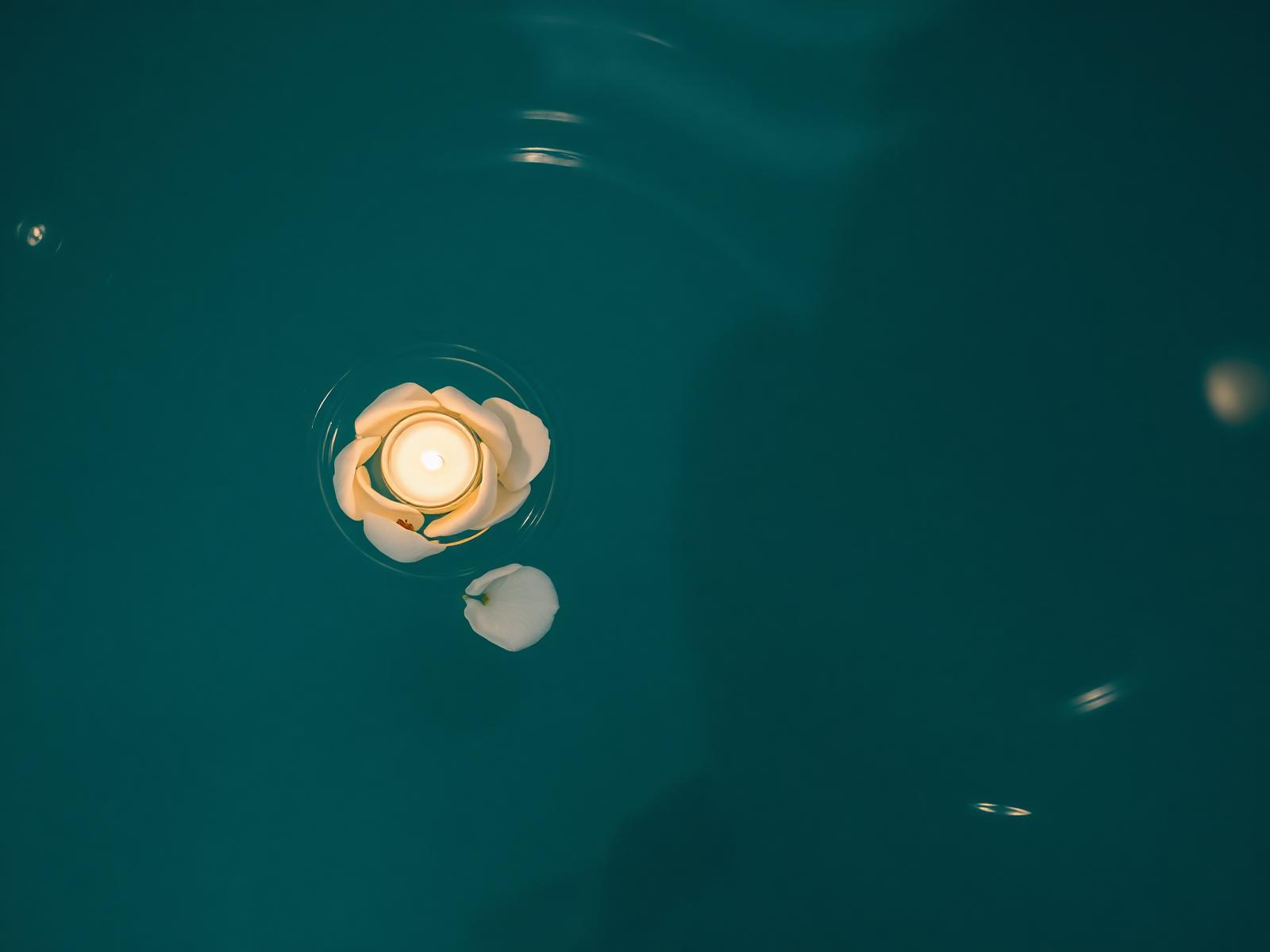 A floating candle on the pool surface